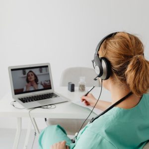 A female doctor conducts a virtual patient consultation via video call, showcasing telemedicine technology.